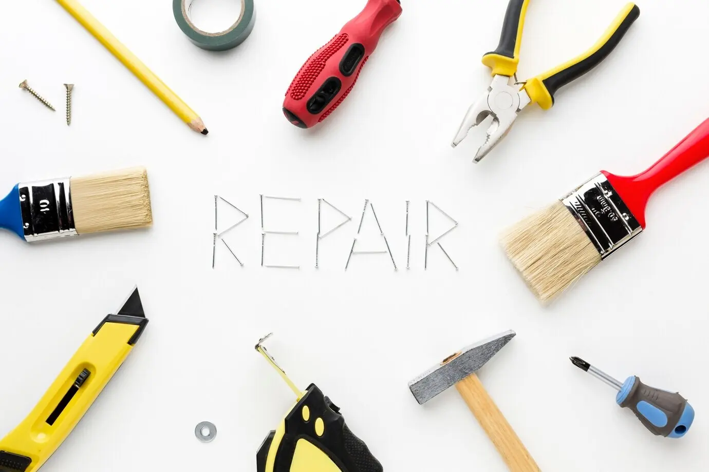 Das Wort „Repair“ mit Nägeln und Reparaturutensilien geschrieben.